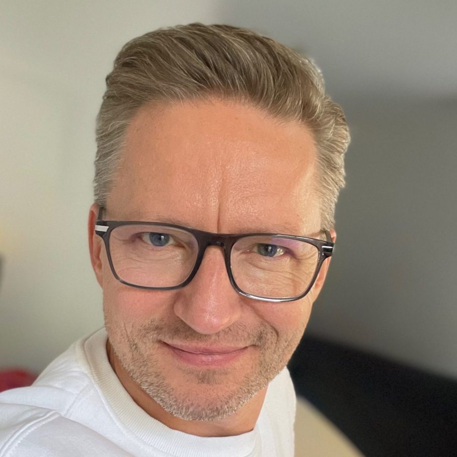 Porträt eines Mannes mit Brille und lächelndem Gesicht. Helle Hintergrundgestaltung.